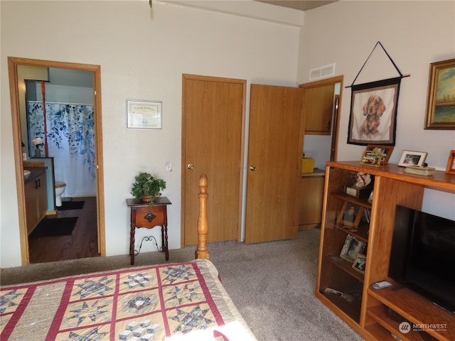 bedroom with ensuite bath and carpet