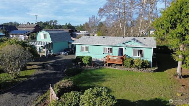 back of house featuring a yard, a carport, and a wooden deck