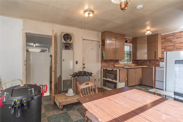 kitchen with tasteful backsplash, white electric range oven, and brick wall