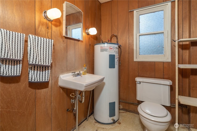 bathroom with sink, wooden walls, electric water heater, and toilet