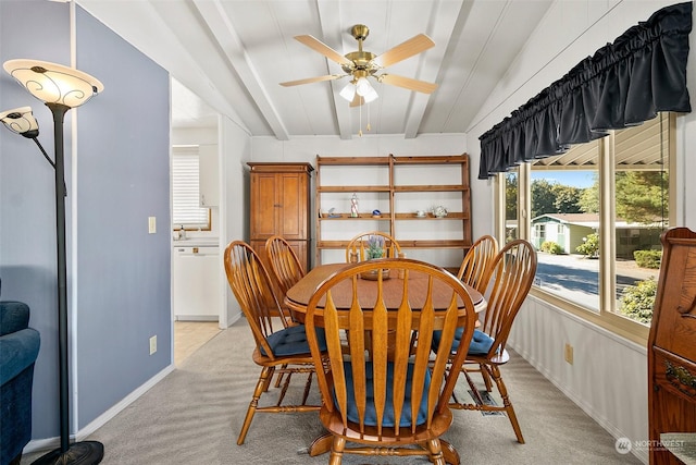 dining space featuring light carpet, plenty of natural light, beam ceiling, a ceiling fan, and baseboards