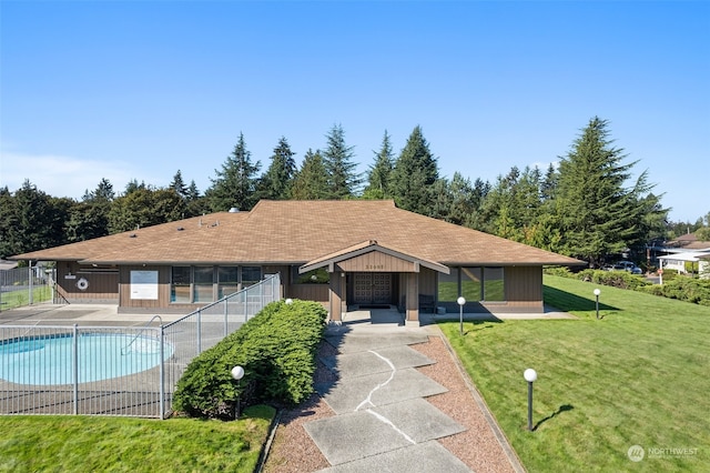 ranch-style house featuring a front yard and a community pool