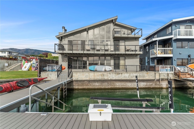 dock area with a water and mountain view and a balcony