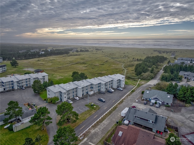 aerial view at dusk featuring a water view