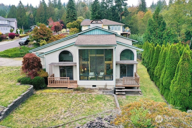 view of front of home featuring a sunroom and a front yard