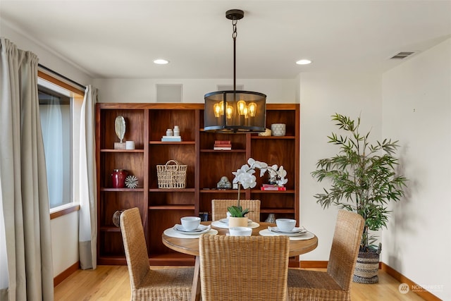 dining area featuring an inviting chandelier and light hardwood / wood-style flooring