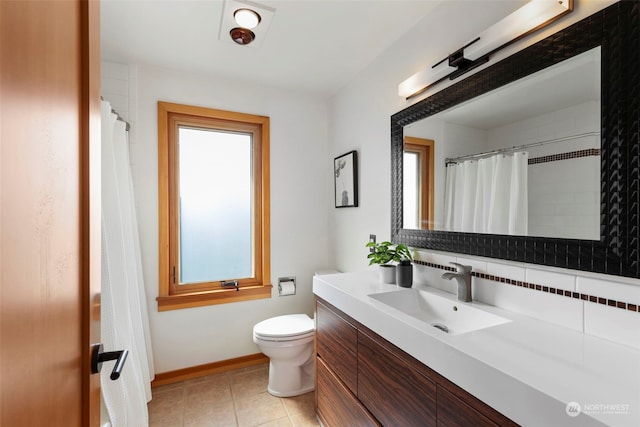 bathroom with vanity, tile patterned floors, toilet, and a wealth of natural light