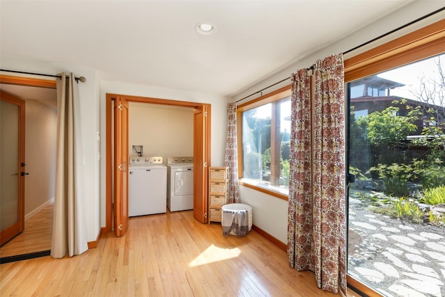 clothes washing area with separate washer and dryer and light hardwood / wood-style floors