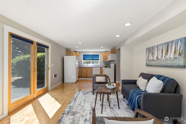 living room featuring sink and light hardwood / wood-style flooring