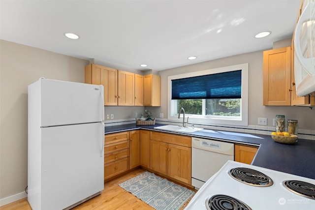 kitchen with white appliances, light brown cabinetry, sink, and light wood-type flooring