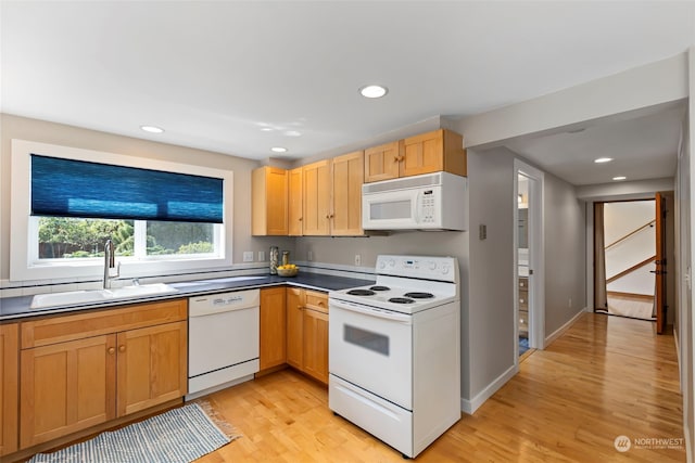 kitchen with white appliances, sink, and light hardwood / wood-style floors