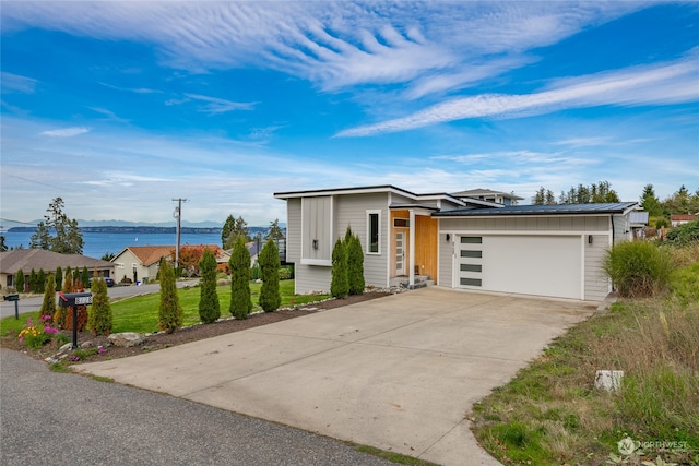 view of front of home with a water view and a garage