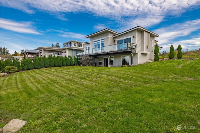 rear view of property featuring a yard and a deck