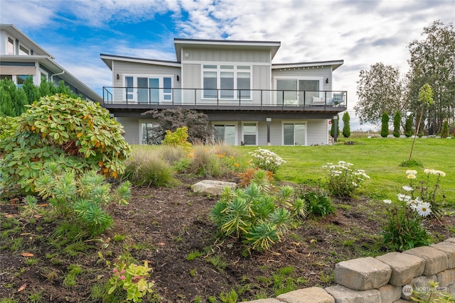 back of house with a balcony and a lawn