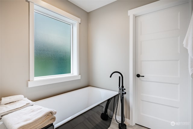 bathroom featuring a bath and a wealth of natural light