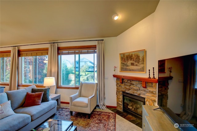 living room with a stone fireplace and vaulted ceiling