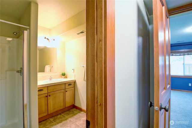 bathroom featuring vanity, a shower, and tile patterned floors