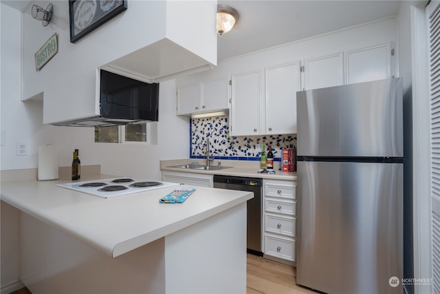 kitchen with light hardwood / wood-style floors, sink, stainless steel appliances, kitchen peninsula, and white cabinets