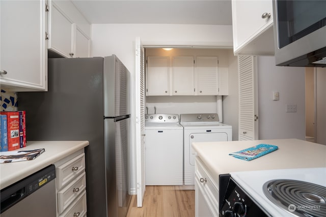 kitchen featuring white cabinets, stainless steel appliances, light wood-type flooring, and washing machine and clothes dryer