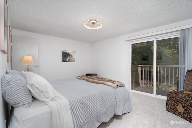 carpeted bedroom with access to outside and a textured ceiling