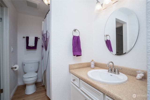 bathroom with vanity, toilet, and hardwood / wood-style flooring