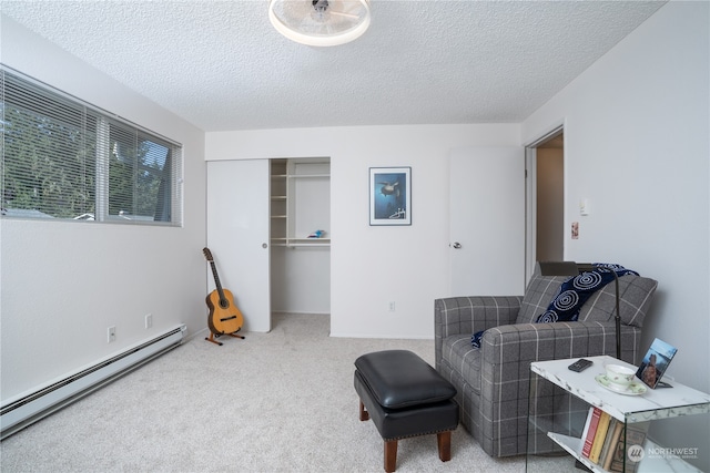 living area featuring a textured ceiling, carpet flooring, and a baseboard heating unit