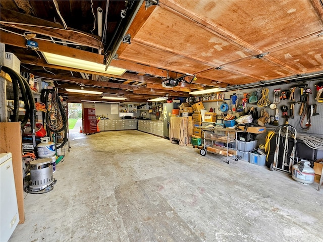 garage with a garage door opener and a workshop area