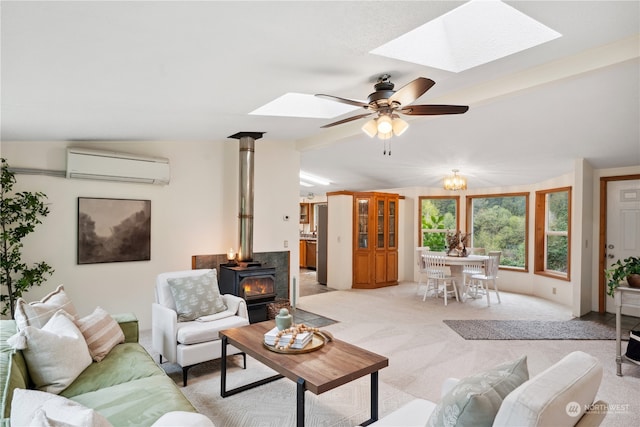 living room featuring a wood stove, light carpet, ceiling fan, vaulted ceiling with skylight, and a wall unit AC