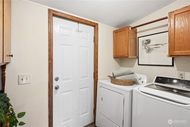 washroom with a textured ceiling, cabinets, and separate washer and dryer