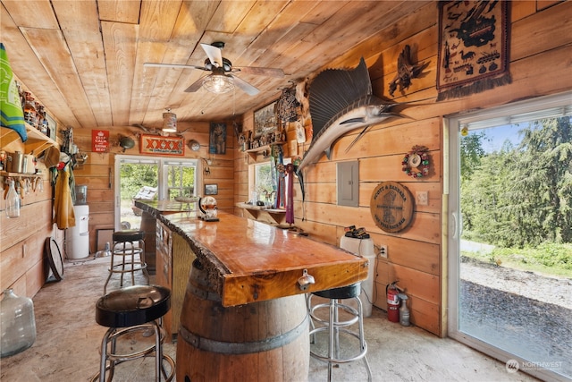 bar with water heater, ceiling fan, wooden ceiling, wooden walls, and electric panel