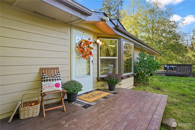 wooden terrace featuring a lawn