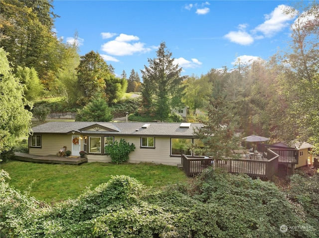 back of house with a wooden deck and a yard