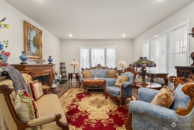 living room with a brick fireplace and wood-type flooring