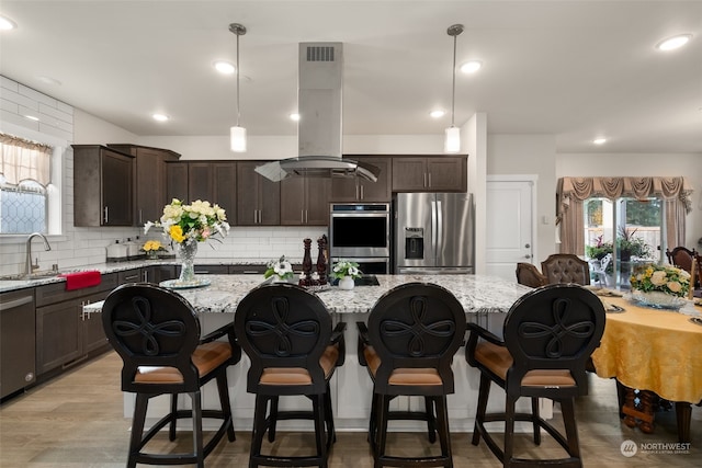 kitchen featuring a kitchen island, appliances with stainless steel finishes, and plenty of natural light