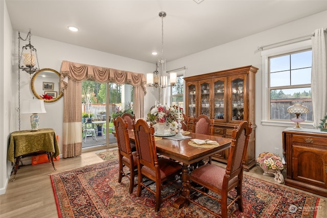 dining space featuring an inviting chandelier and light hardwood / wood-style floors