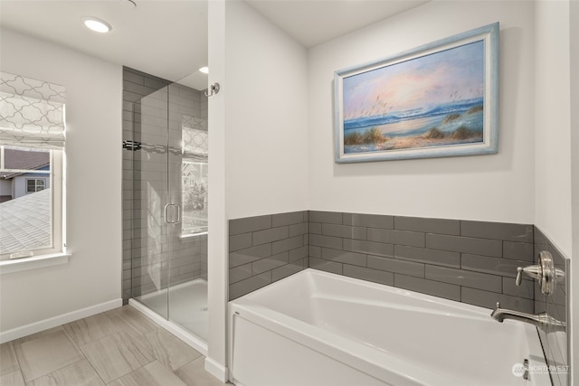 bathroom featuring shower with separate bathtub