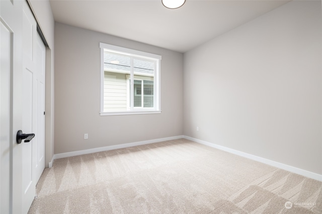 unfurnished bedroom with light carpet and a closet