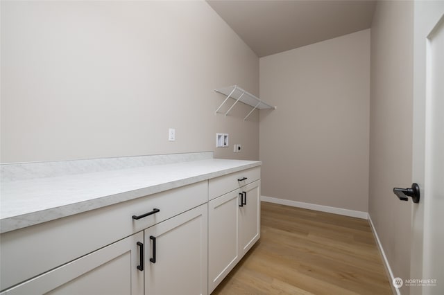 clothes washing area with electric dryer hookup, hookup for a washing machine, cabinets, and light wood-type flooring