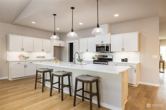 kitchen featuring white cabinets, an island with sink, and appliances with stainless steel finishes