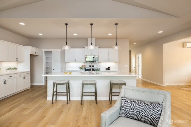 kitchen featuring decorative backsplash, pendant lighting, an island with sink, and stainless steel appliances