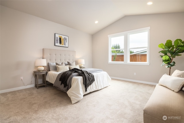 bedroom featuring light colored carpet and vaulted ceiling