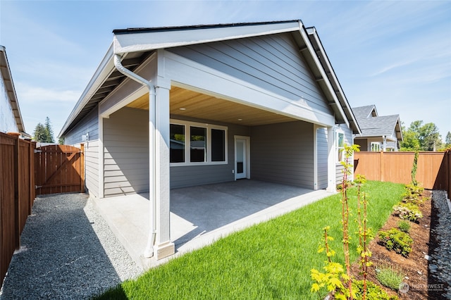 back of house with a yard and a patio area