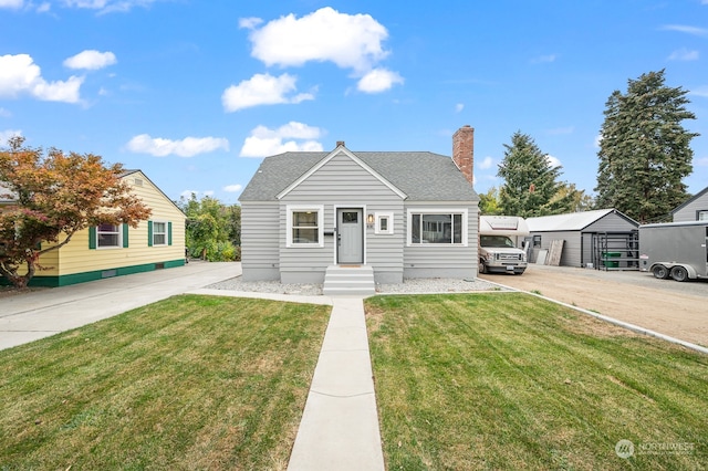 bungalow-style house featuring a front yard, an outbuilding, and a carport