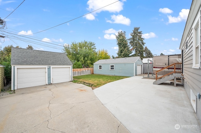 view of patio with a garage and an outbuilding