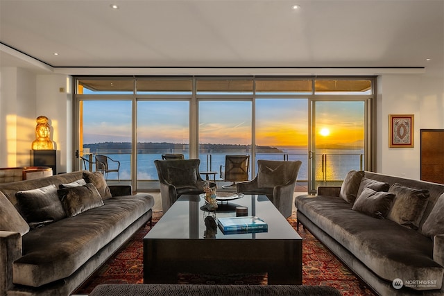 living room with a water view and a wall of windows