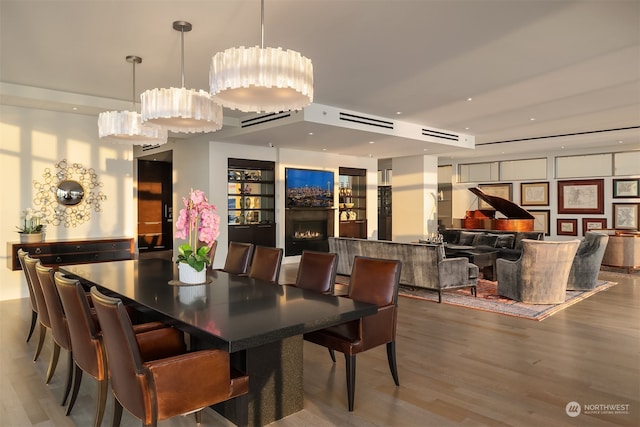 dining area featuring wood-type flooring and an AC wall unit