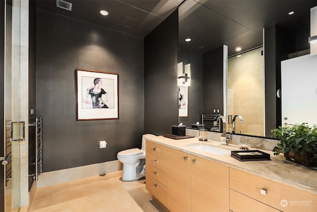 bathroom with tile patterned floors, a shower with shower door, vanity, and toilet