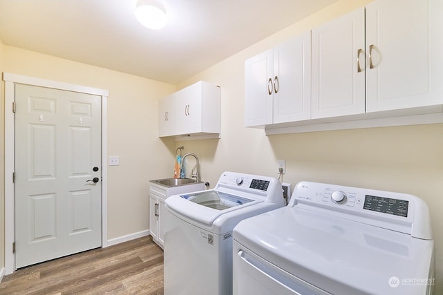 laundry area featuring hardwood / wood-style flooring, cabinets, sink, and separate washer and dryer