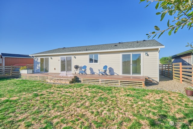 rear view of property with a deck and a lawn