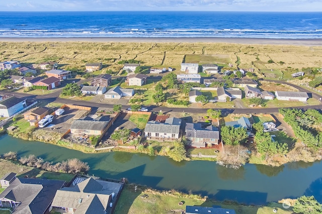 drone / aerial view with a water view and a beach view